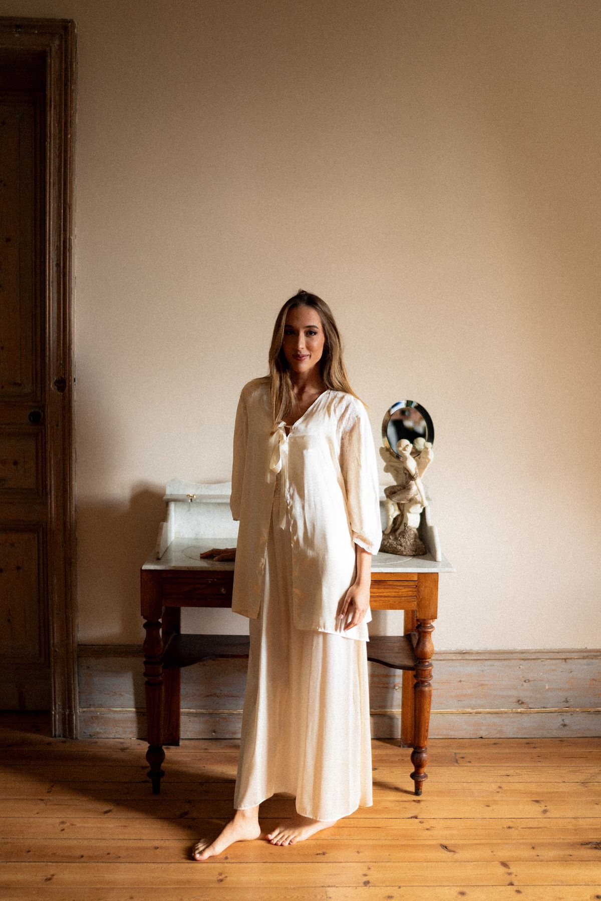 Isadora & Hugo — the bride in her cream robe in a chateau bedroom, spring wedding in Nouvelle-Aquitaine