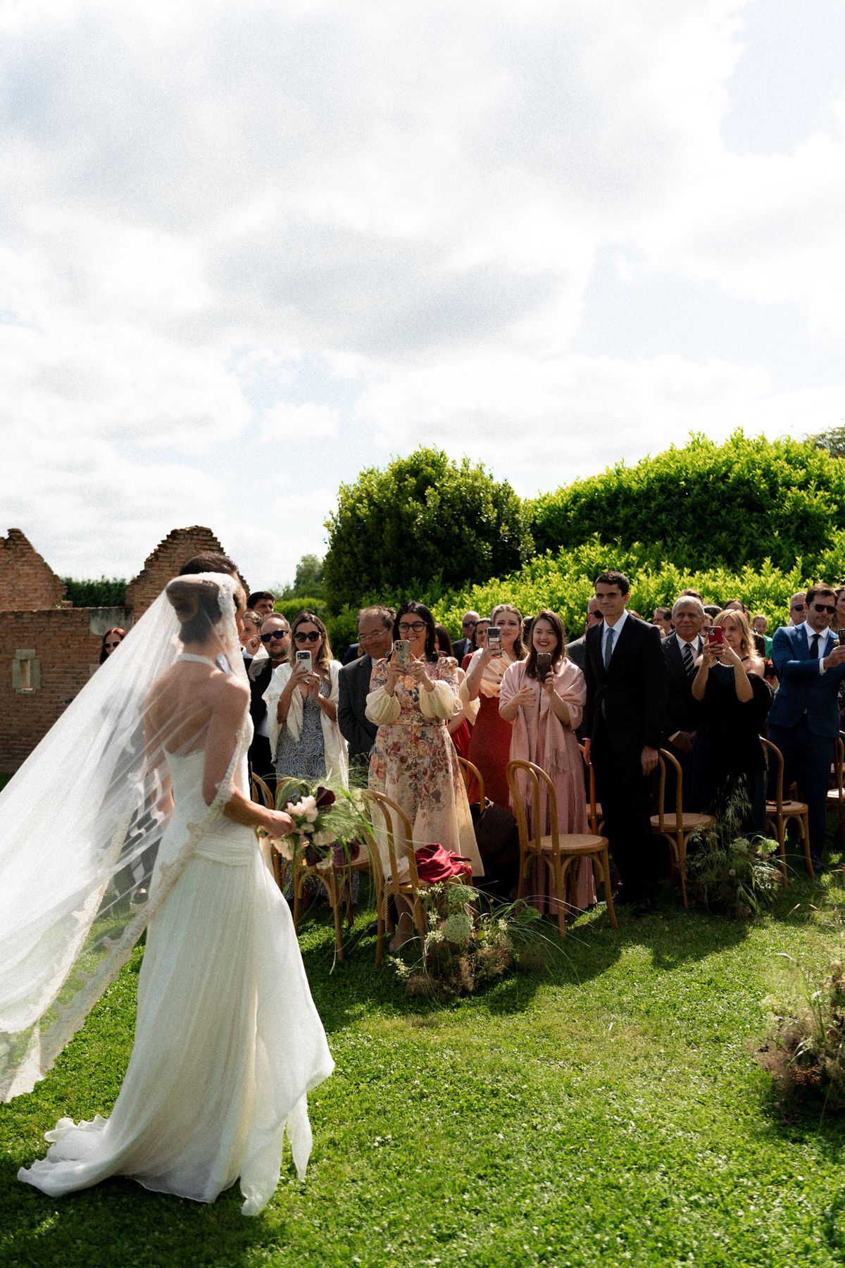 Isadora & Hugo — the bride walking the aisle as guests rise, spring wedding in Nouvelle-Aquitaine