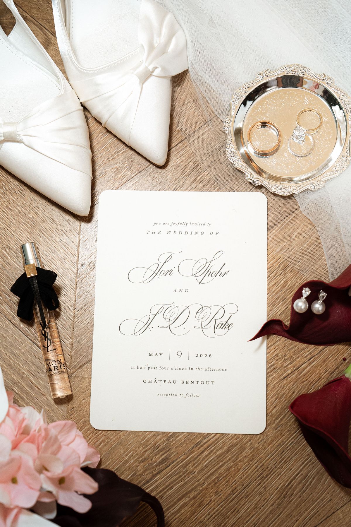 Jori's wedding shoes, rings, and invitation suite arranged as a flat lay