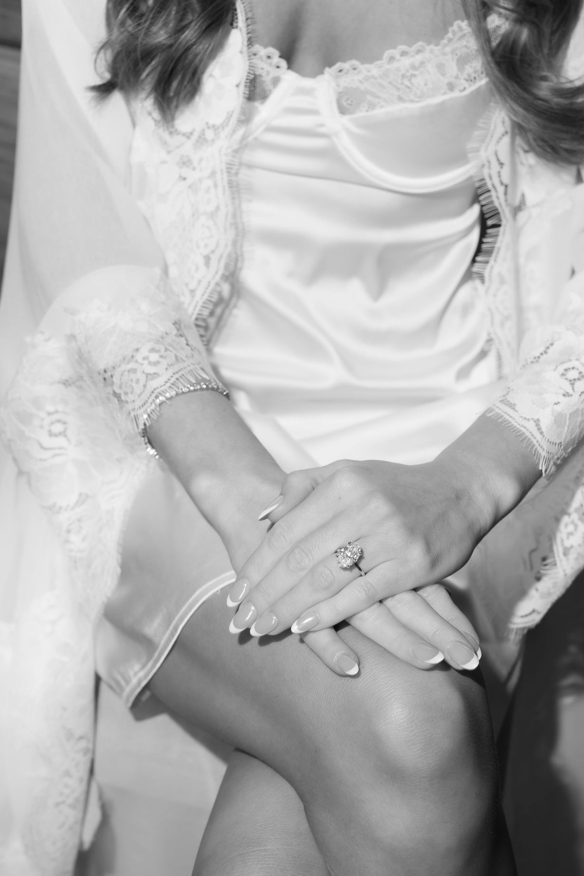 A black-and-white detail of Jori's hands and engagement ring