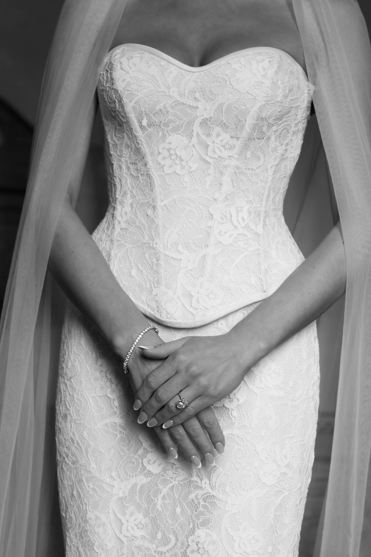 Close-up of hands fastening the buttons on Jori's wedding gown