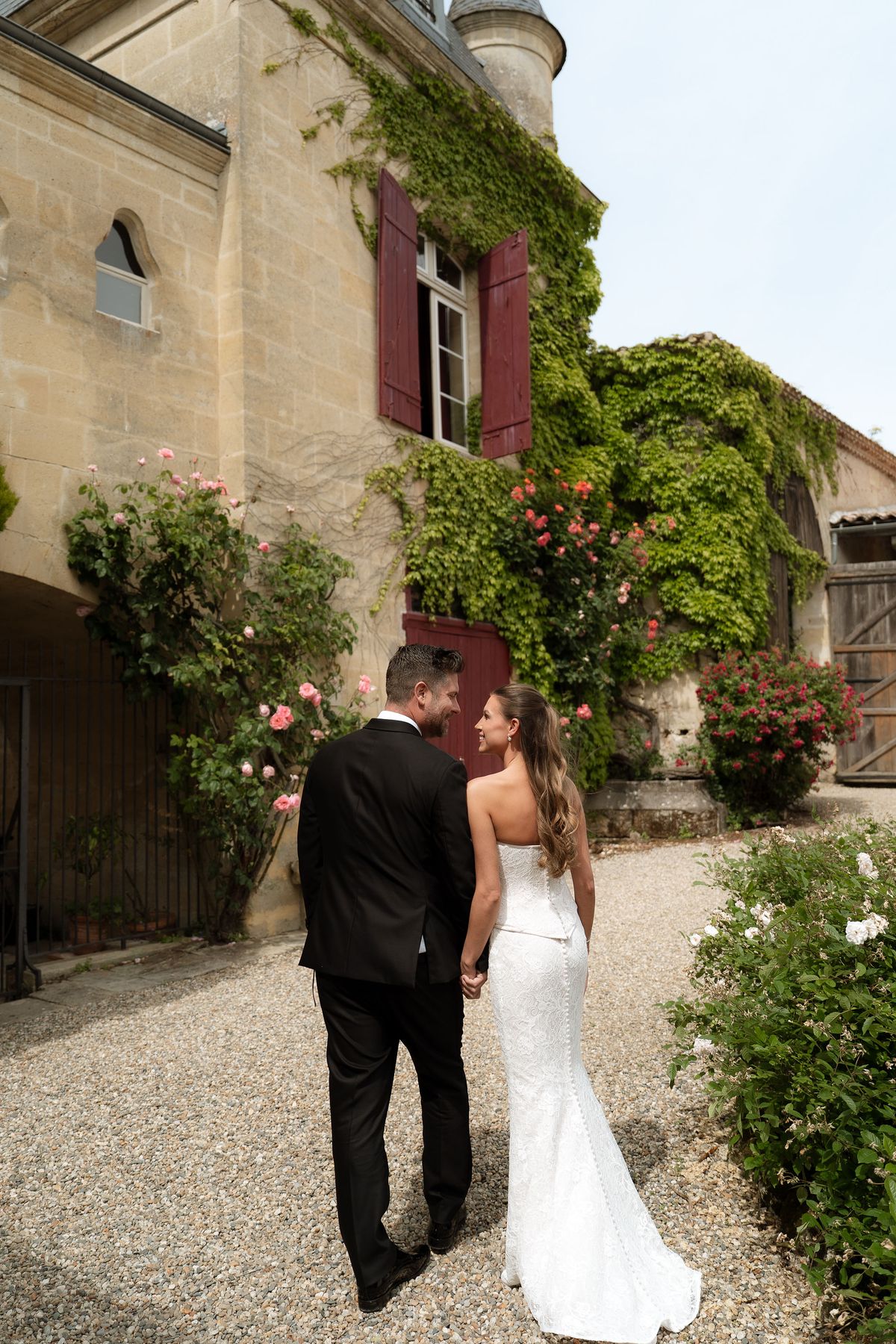 Jori and JD walking together under an ivy-covered archway
