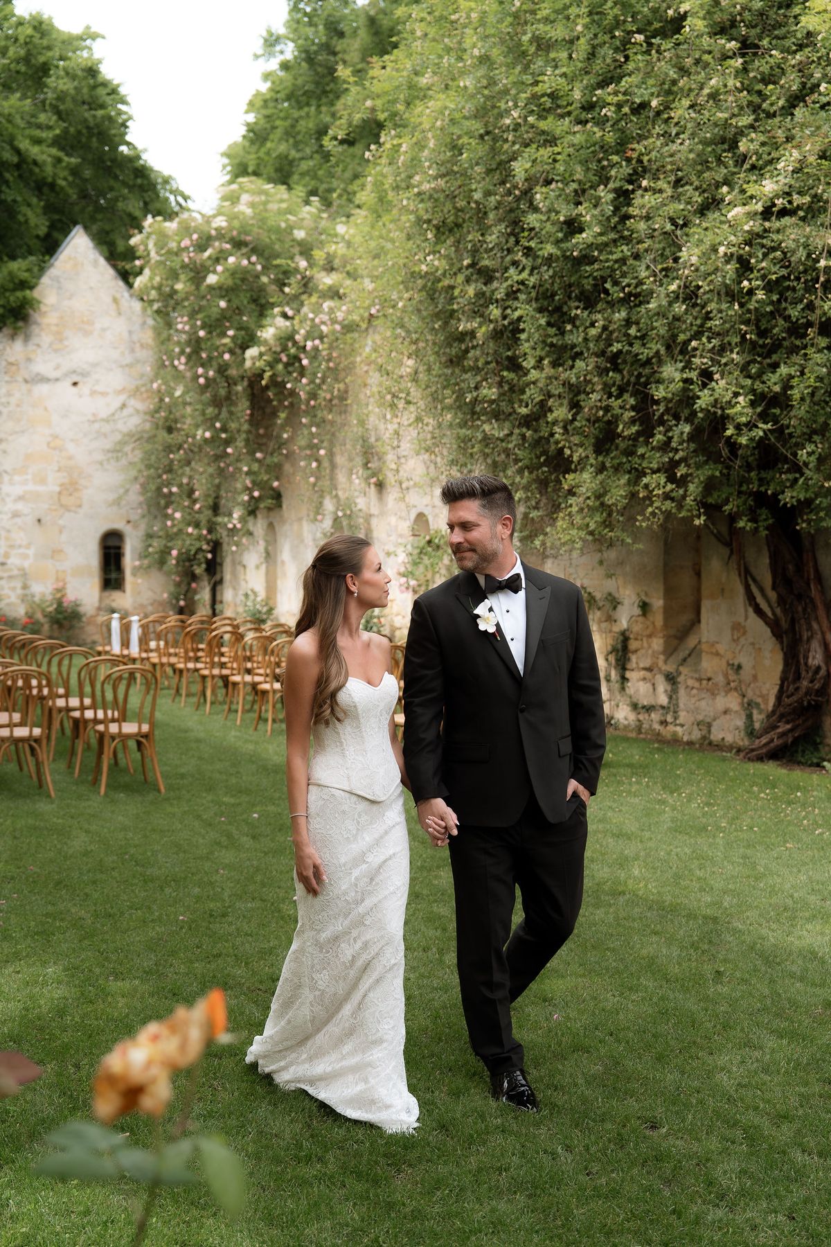Jori and JD walking together through a garden archway