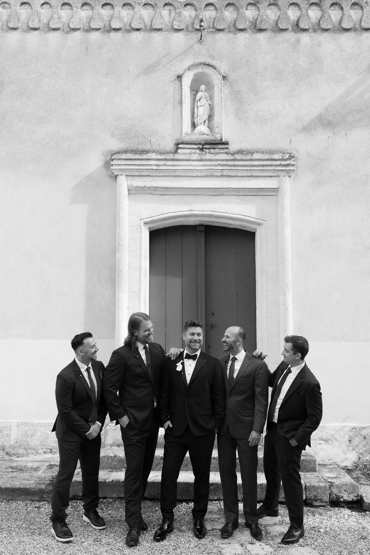 JD's groomsmen gathered outside the stone chapel doorway