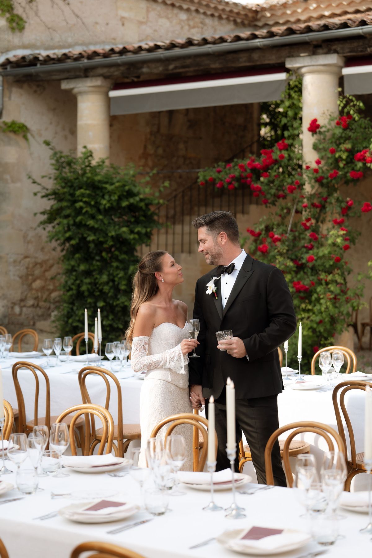 Jori and JD talking with a guest on the rose-lined courtyard during cocktail hour