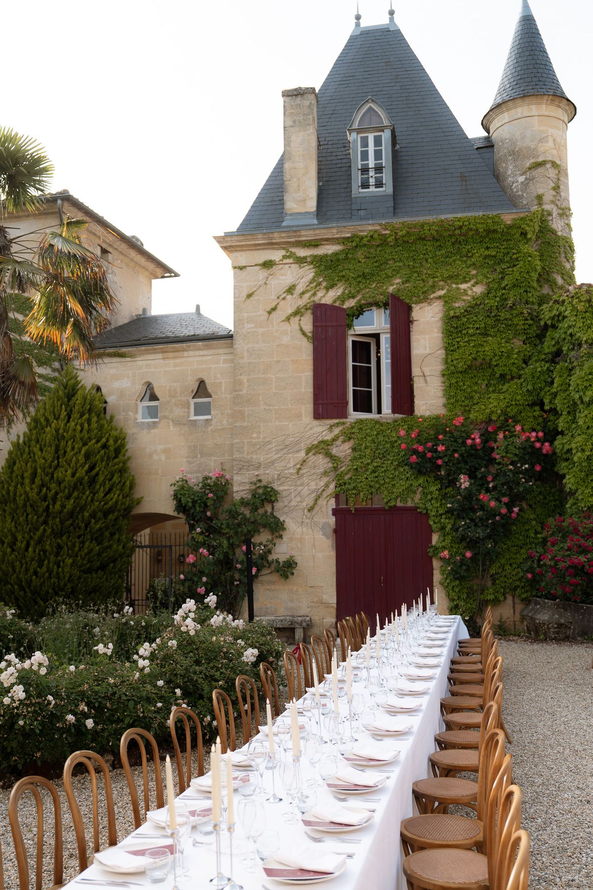 A long dining table set for the reception with the château's turret in view