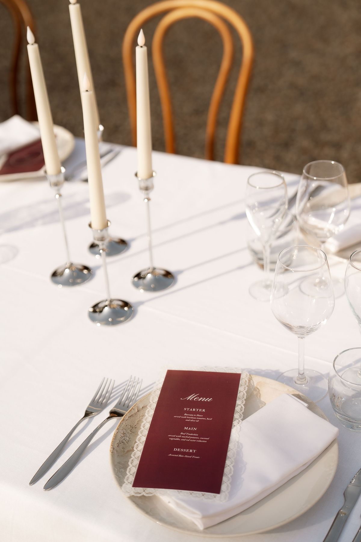 A place setting with taper candles and a menu card