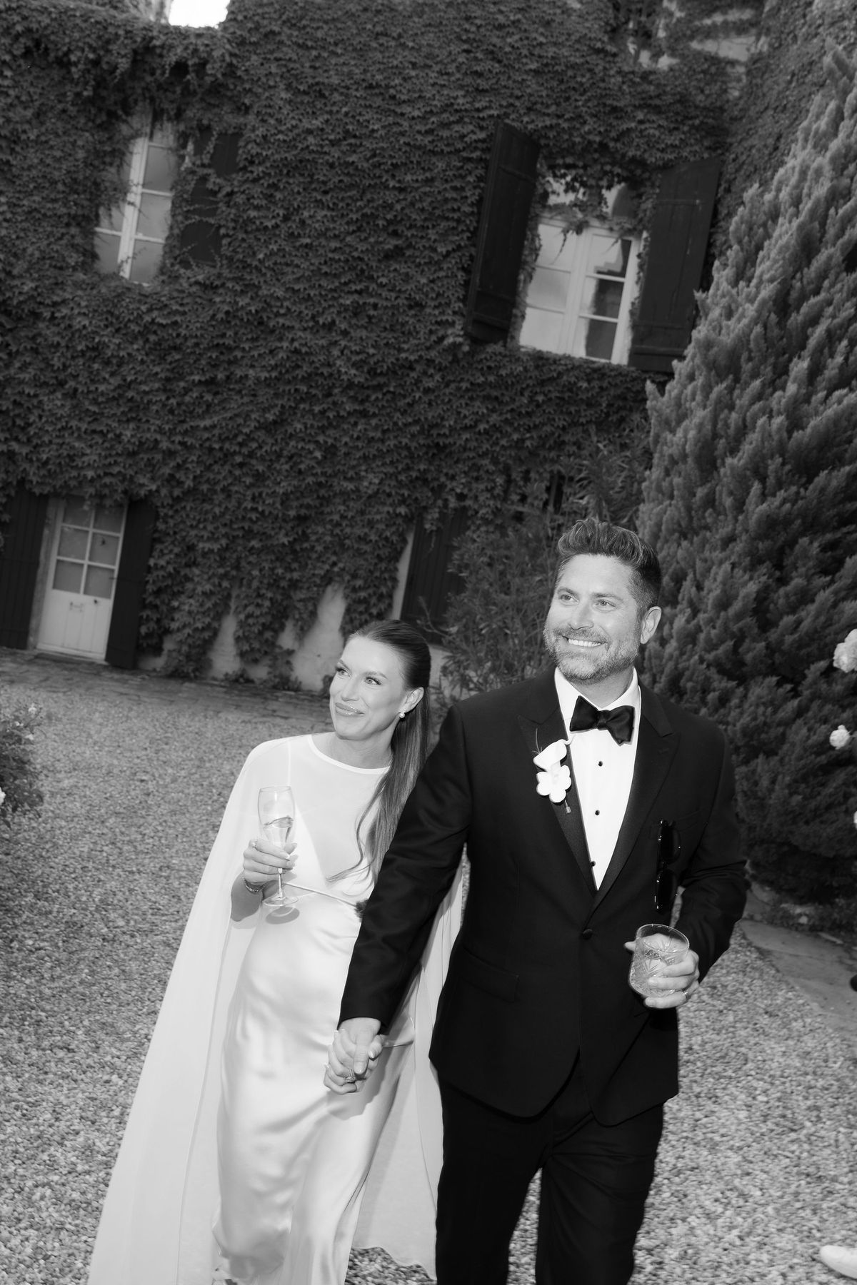A black-and-white photo of Jori and JD embracing in front of the château