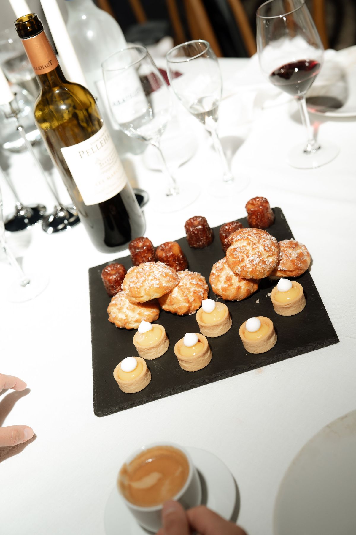 A bottle of wine and a plate of canelés on the reception table