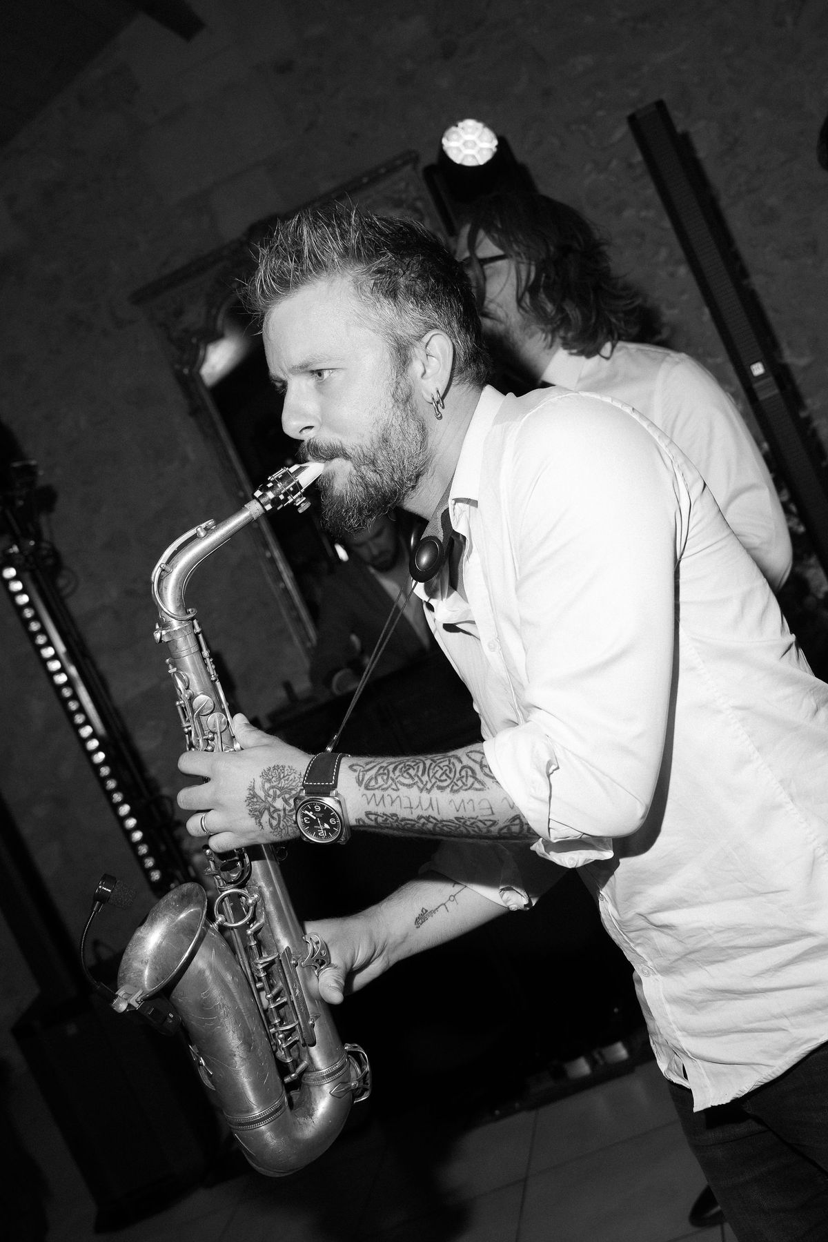 A black-and-white photo of a saxophonist performing during the reception