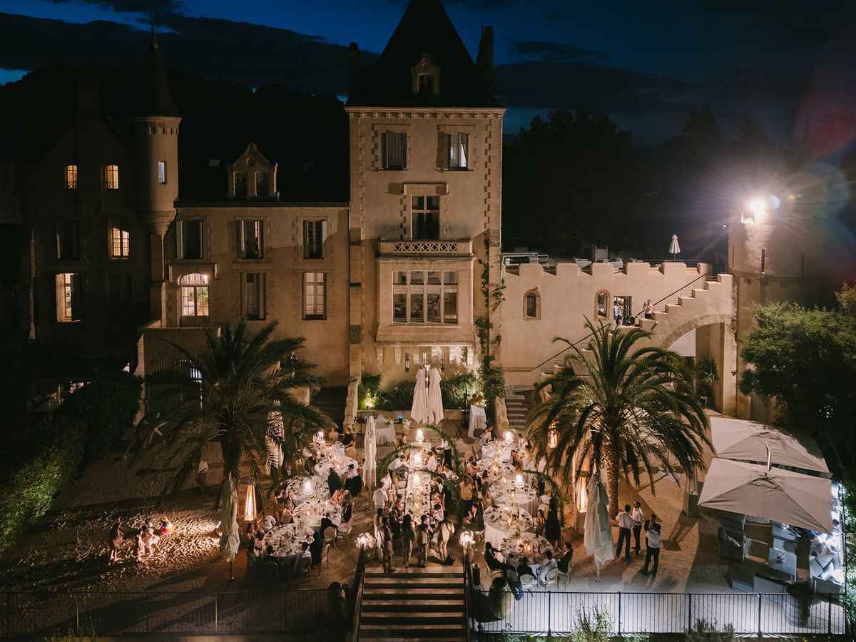 Château les Carrasses lit up at night above the candlelit dinner terrace