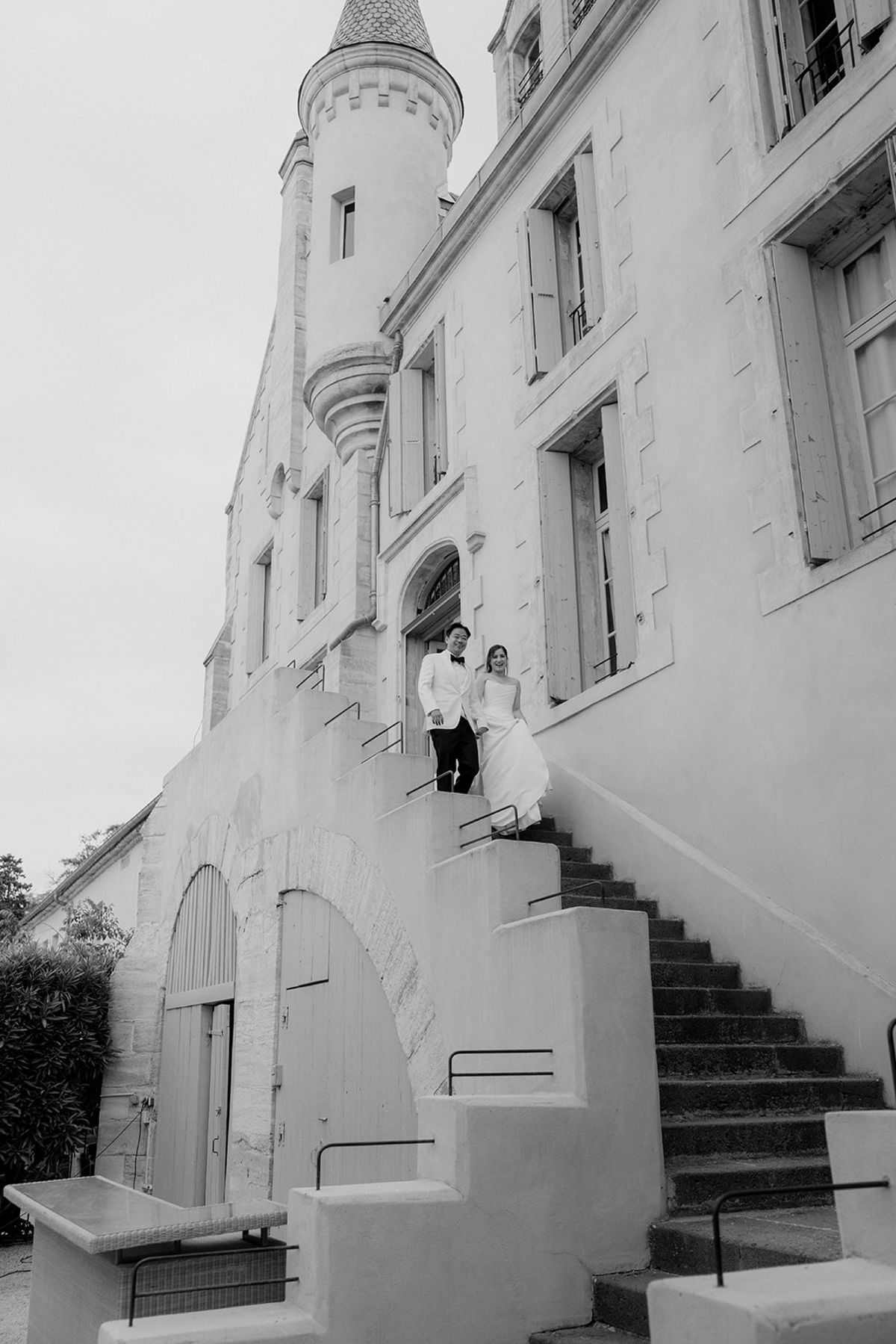 Black and white view of Carina and Stefan on the outdoor staircase of Château les Carrasses