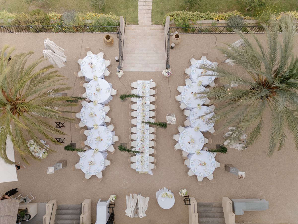 Aerial view of the dinner tables arranged between palm trees on a terrace
