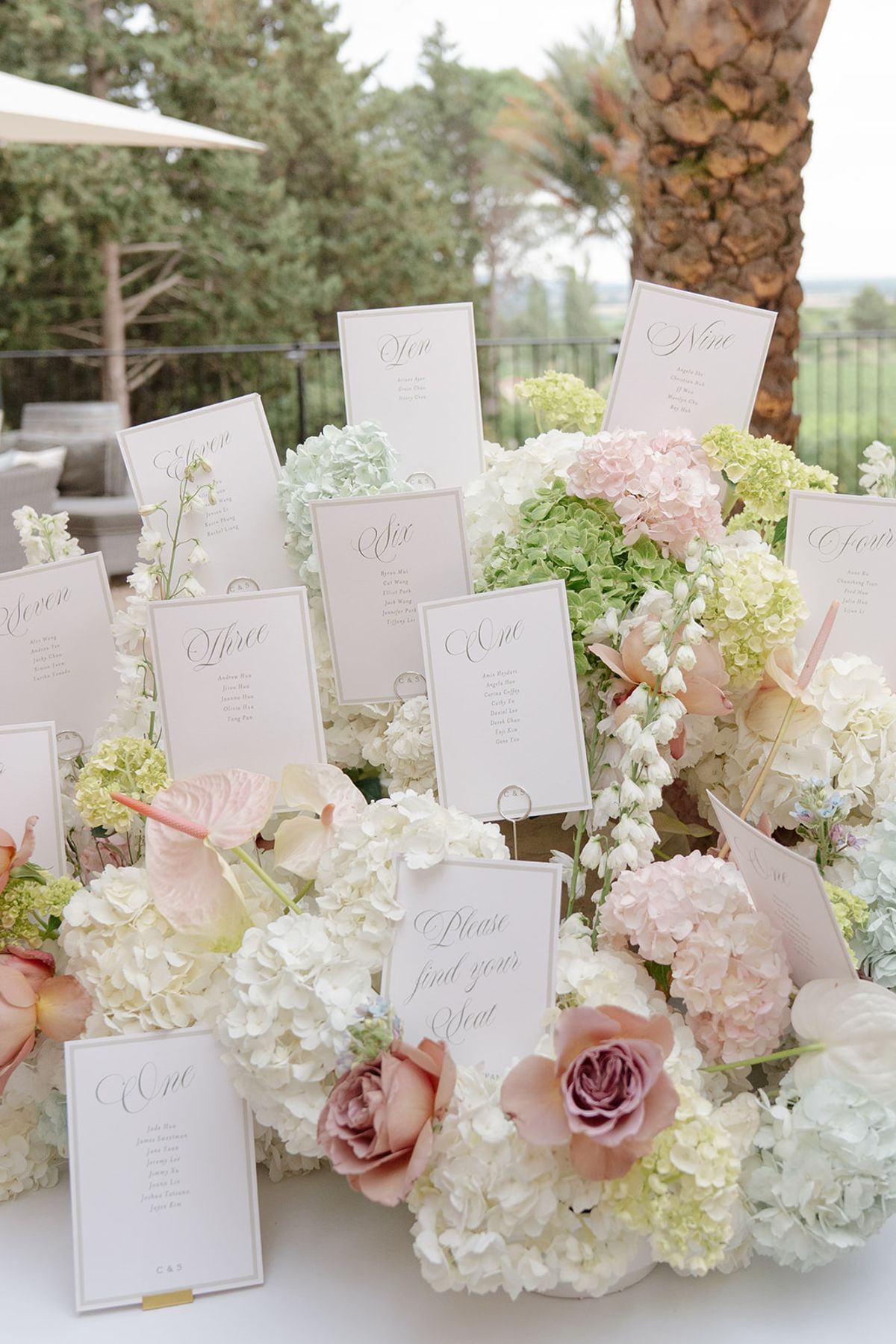 Close view of escort cards set into hydrangea, roses and anthurium