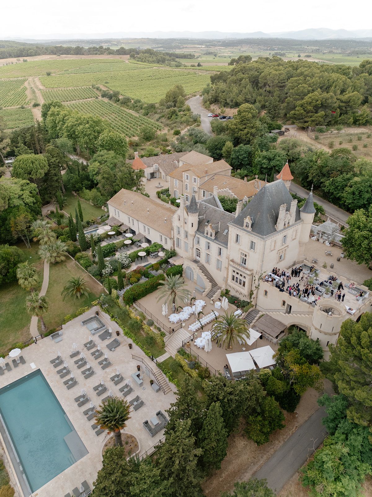 Aerial view of Château les Carrasses, its pool and the dinner set-up among vineyards