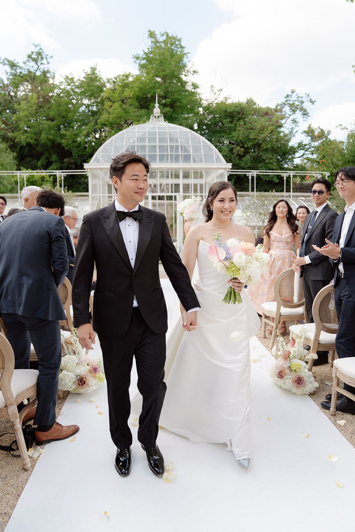 Carina and Stefan walking back down the aisle hand in hand as guests applaud