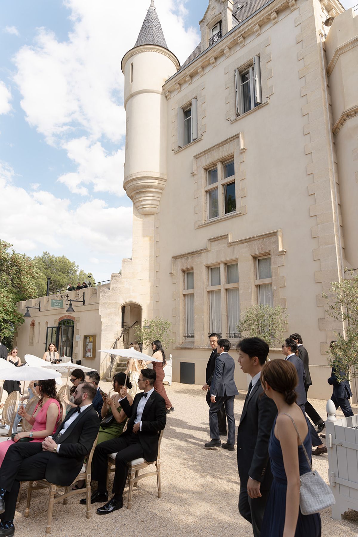 Guests taking their seats for the ceremony beside the tower of Château les Carrasses
