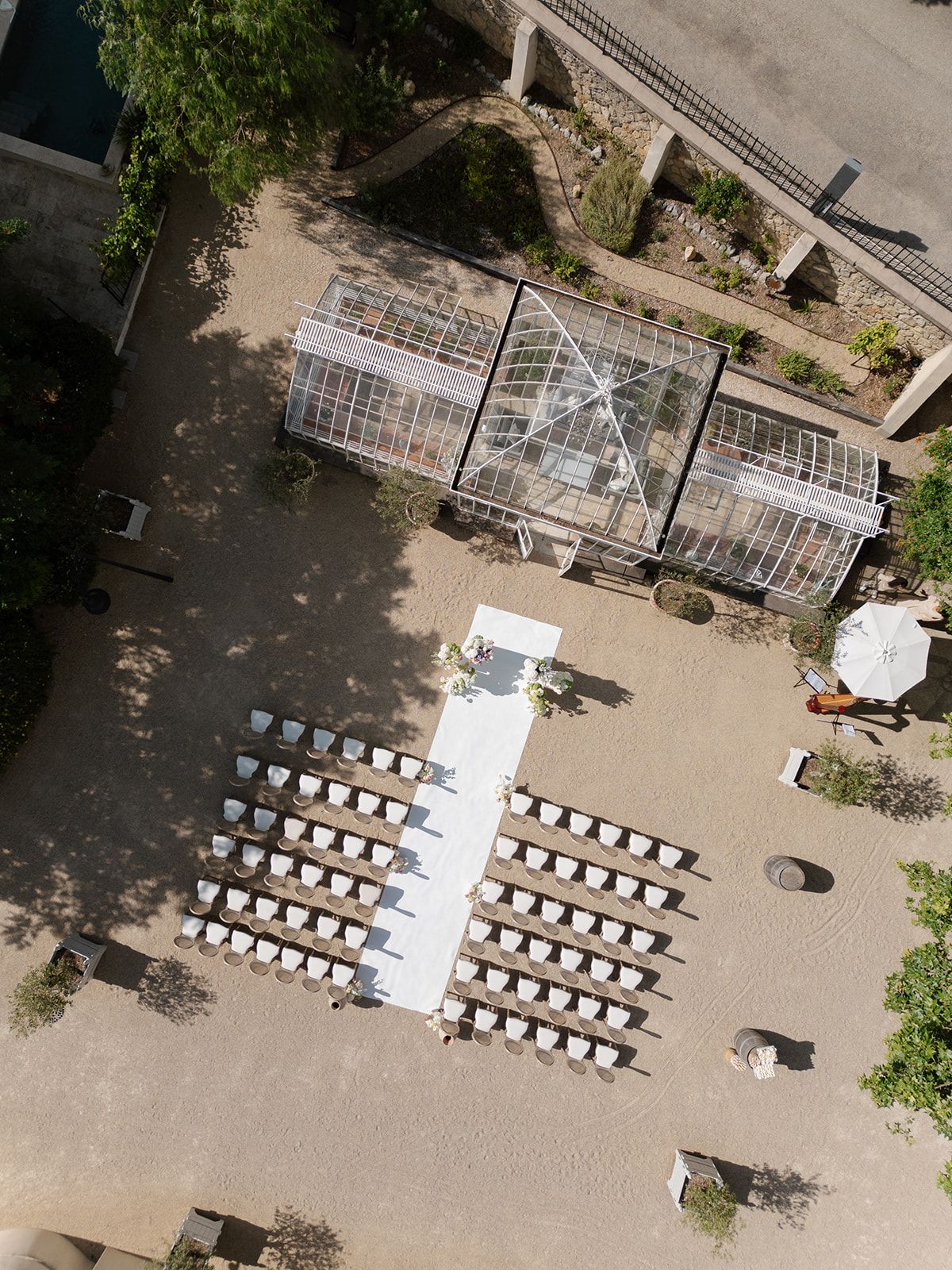 Aerial view of the white aisle and chairs set in the courtyard beside the greenhouse