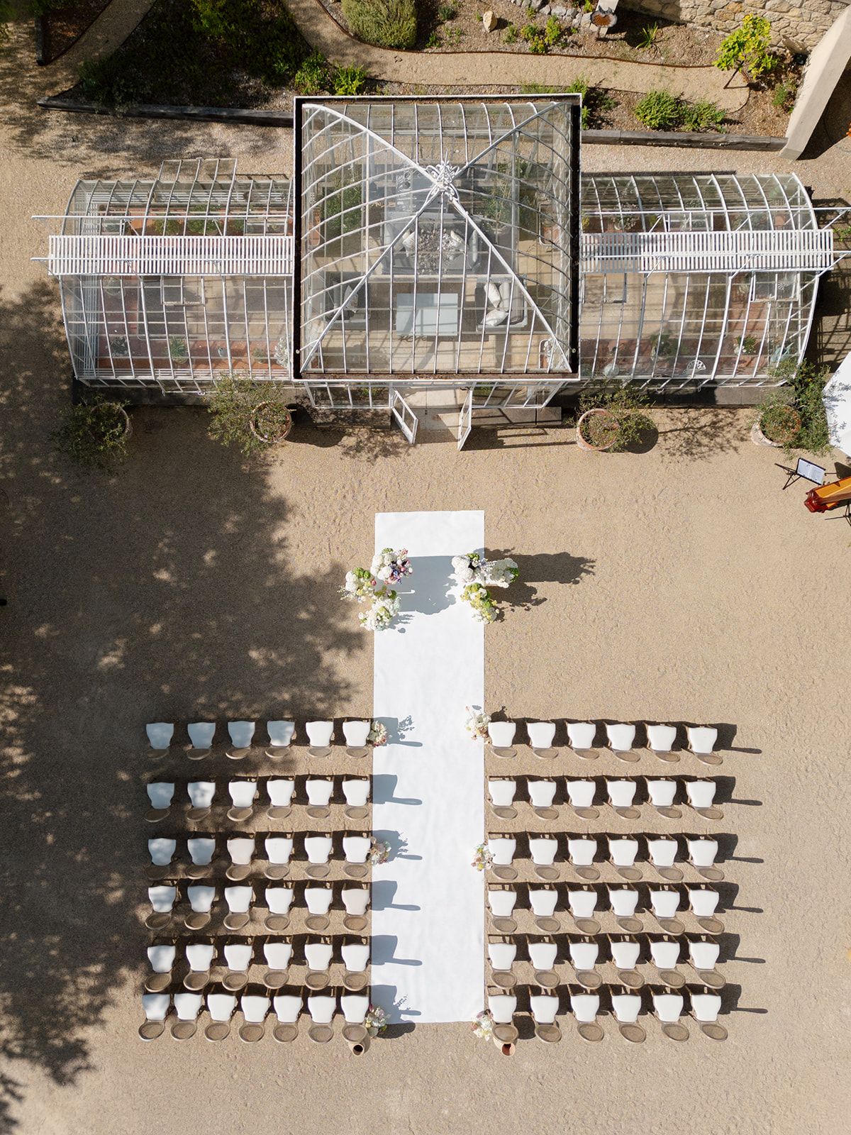 Aerial view of the ceremony aisle and seating in front of the glass greenhouse
