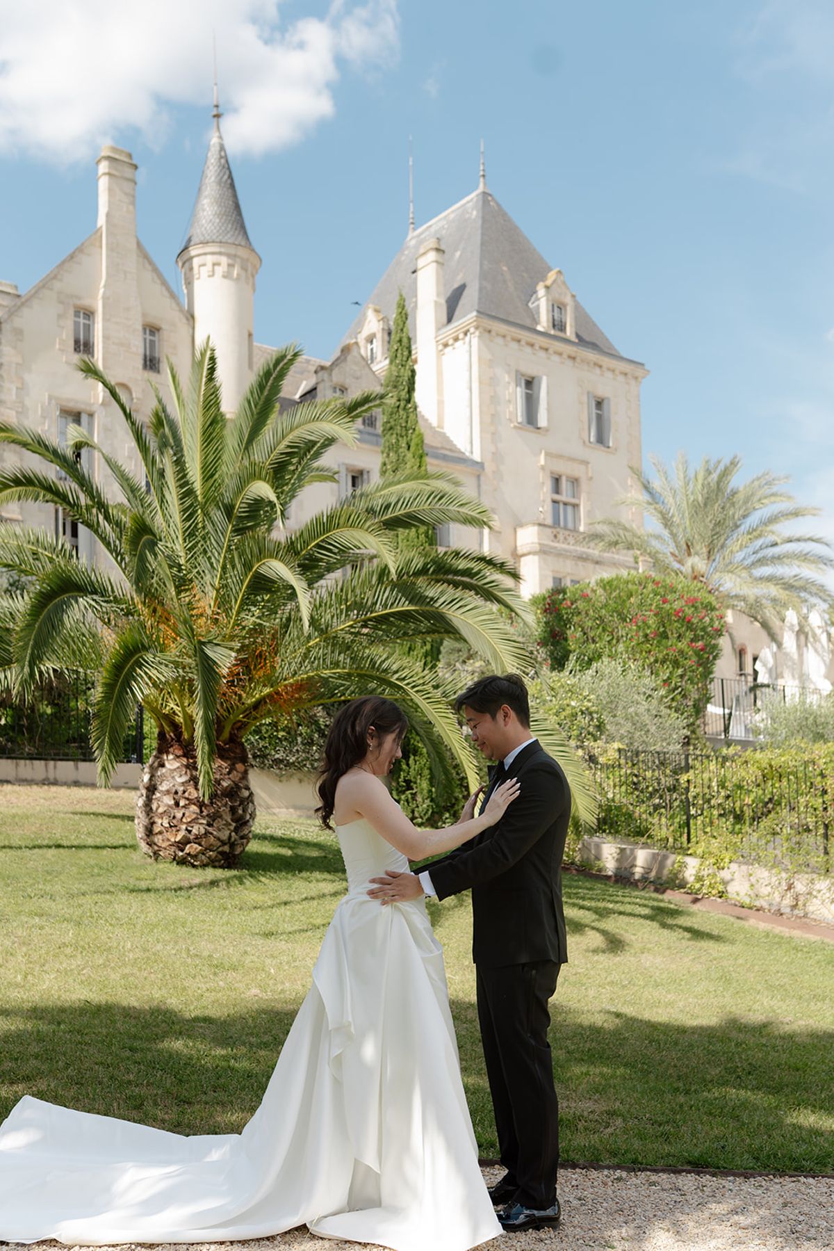 Carina and Stefan facing each other on the lawn in front of the château at their first look