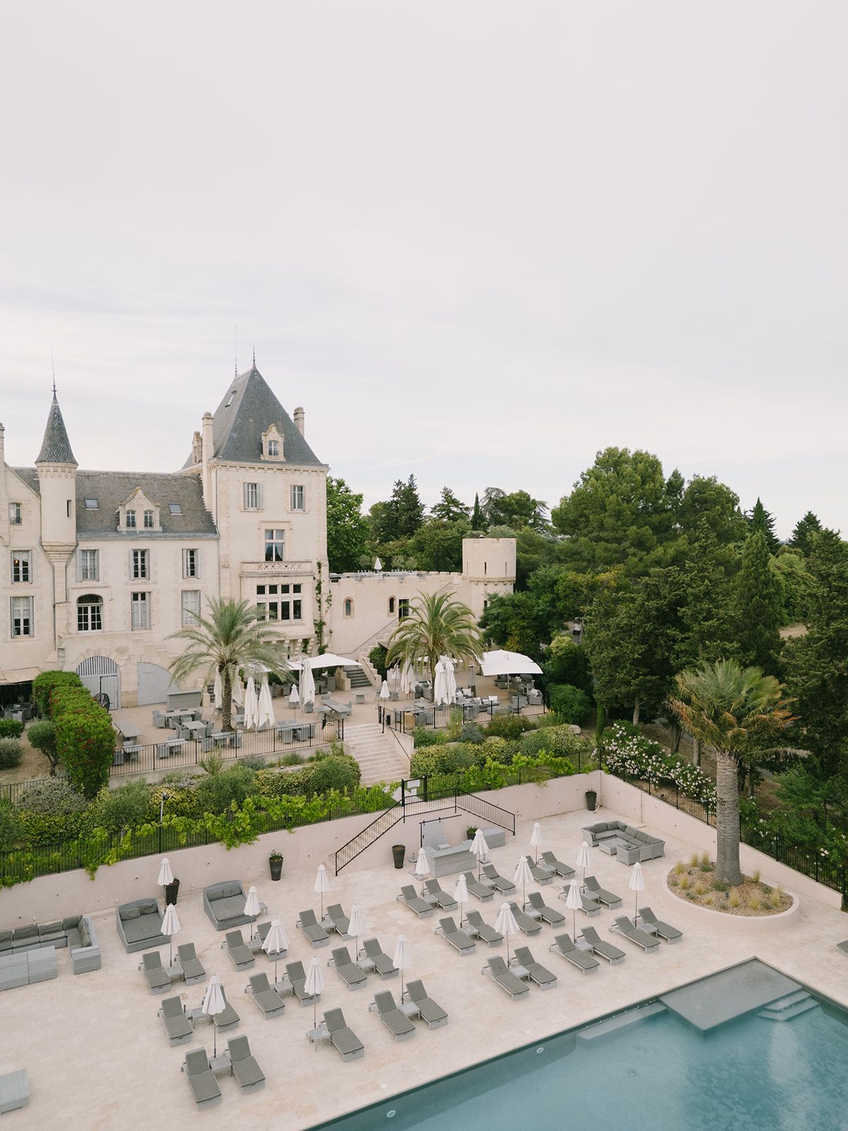 High view of Château les Carrasses and the pool terrace with rows of sun loungers