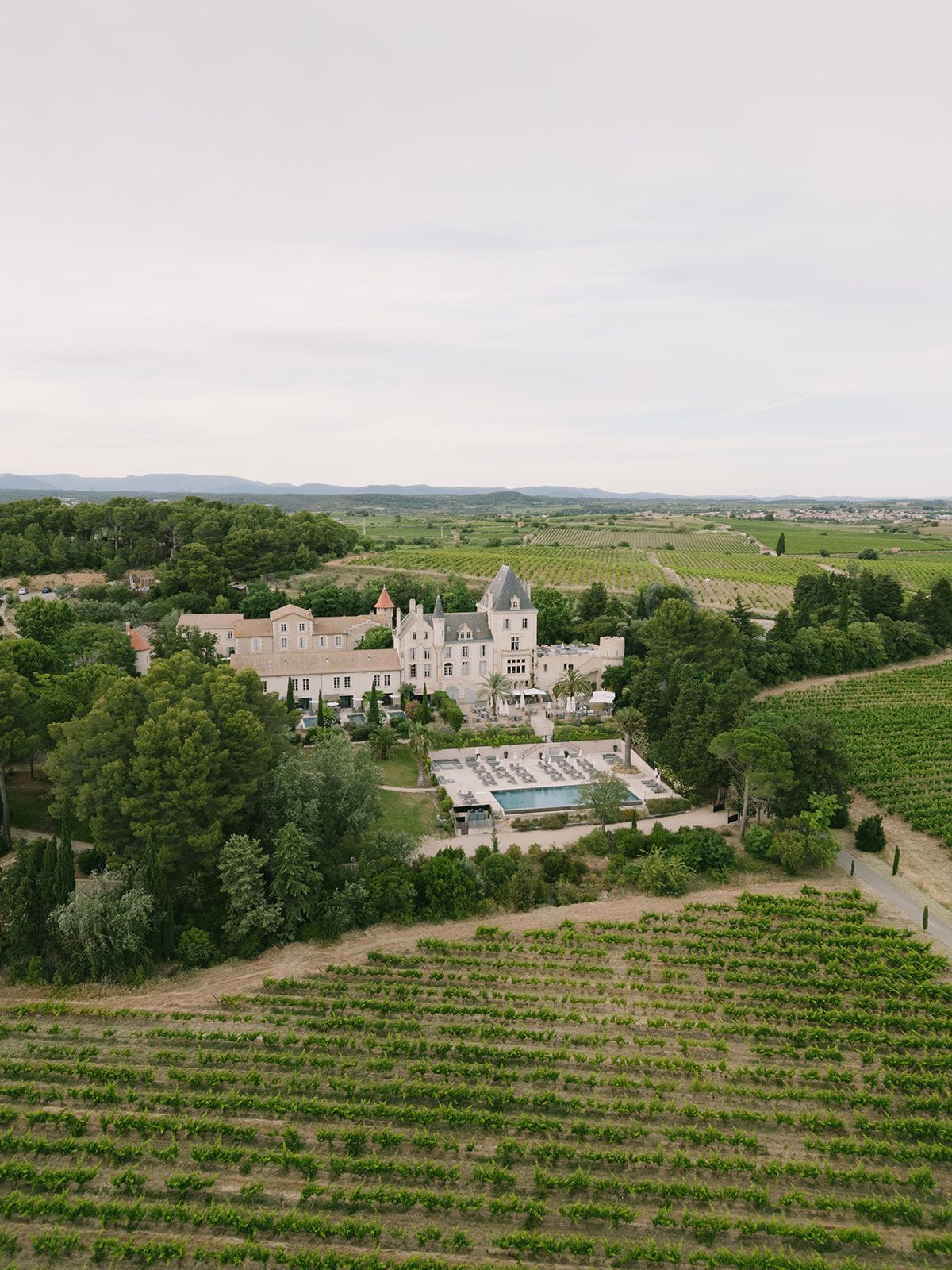 Aerial view of vineyards leading up to Château les Carrasses and its grounds in the Languedoc