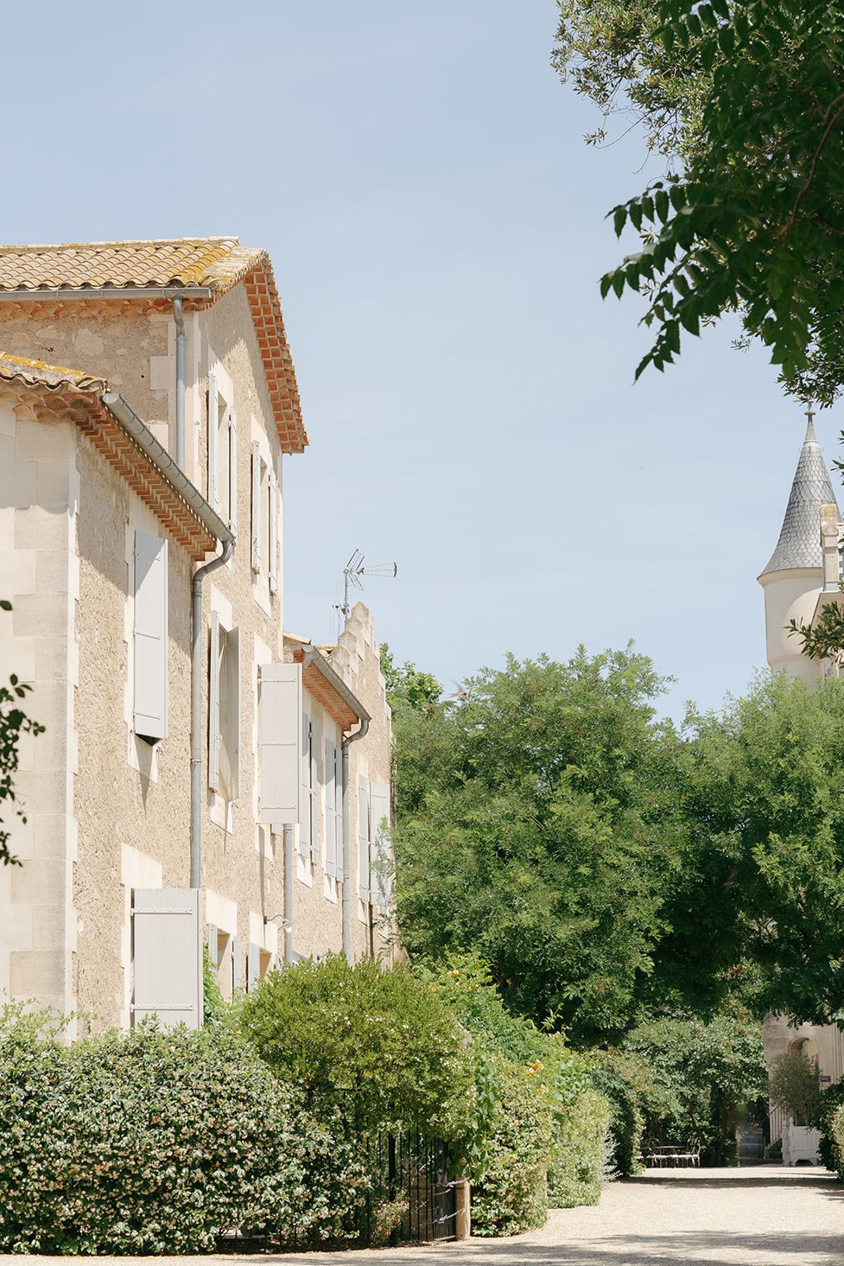 Stone buildings of the estate with a turret glimpsed through the trees