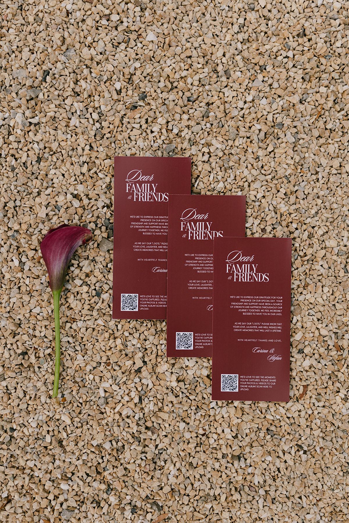 Burgundy welcome cards for family and friends beside a calla lily at the welcome party the day before