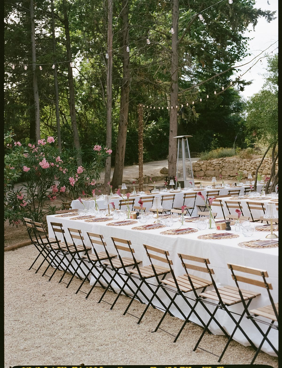 Long tables laid in white under the trees at the welcome party the day before