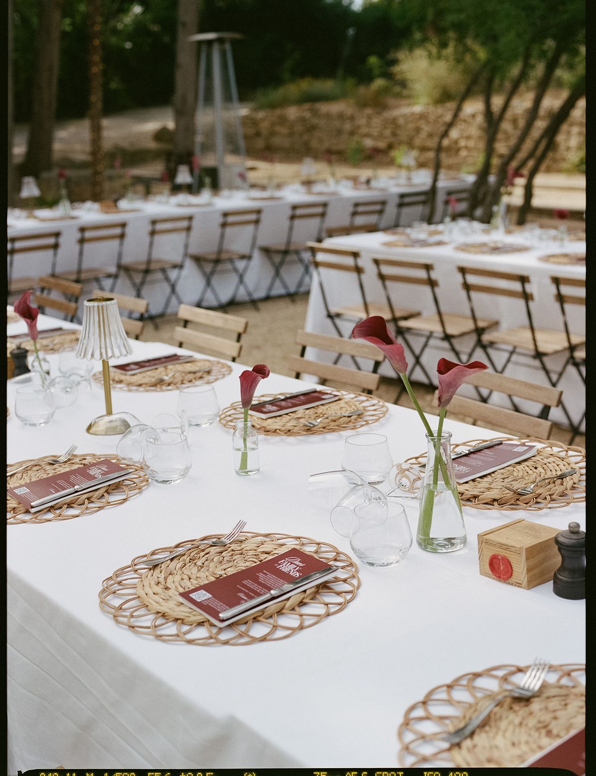 Place settings with woven rattan chargers and burgundy menus at the welcome party the day before