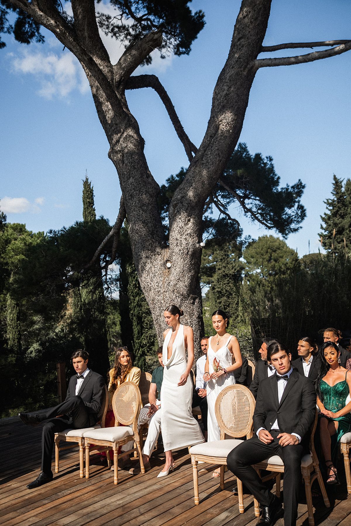 Guests take their seats on the ceremony deck as the sea catches the afternoon light.