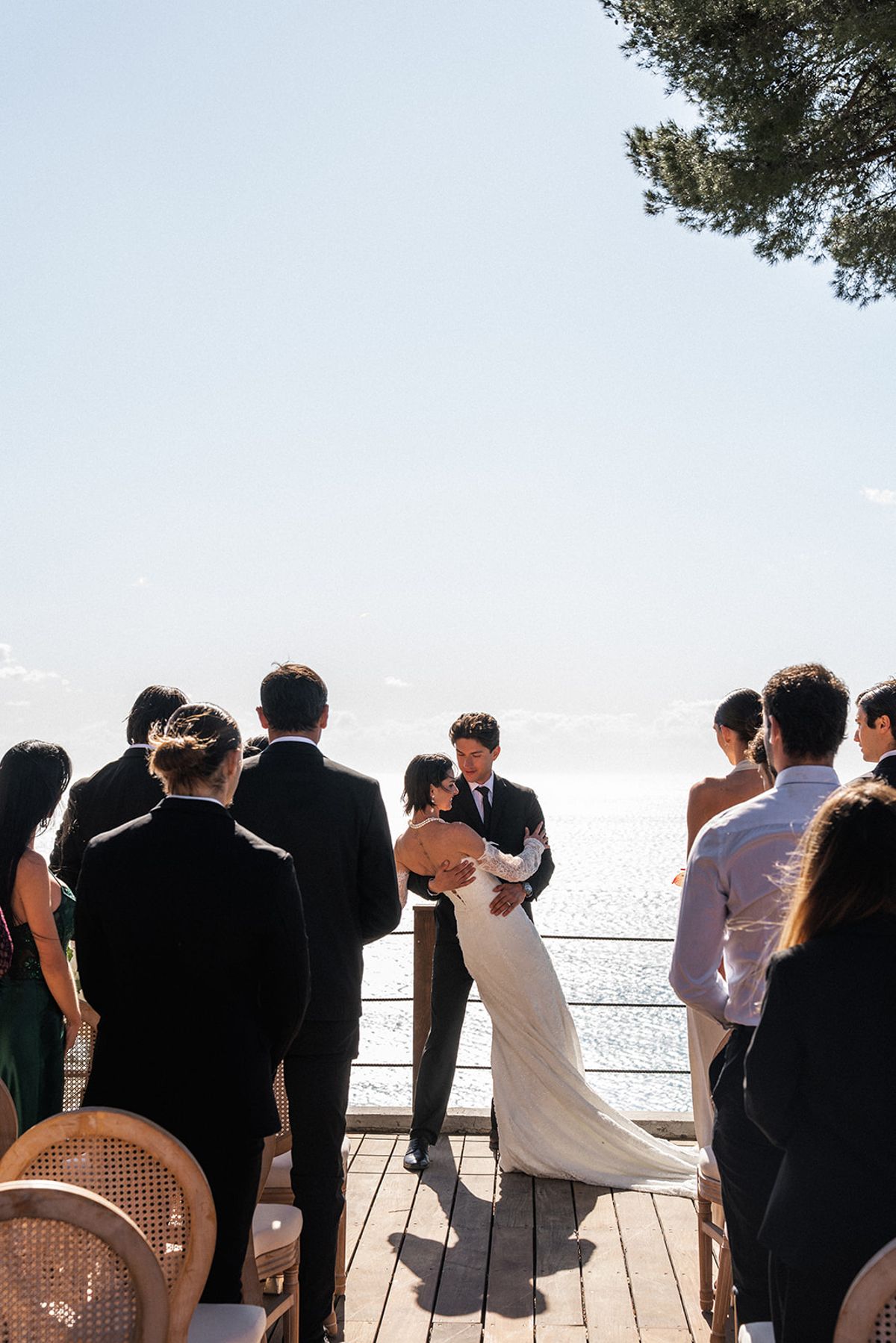The couple face each other during the ceremony, guests seated on either side.