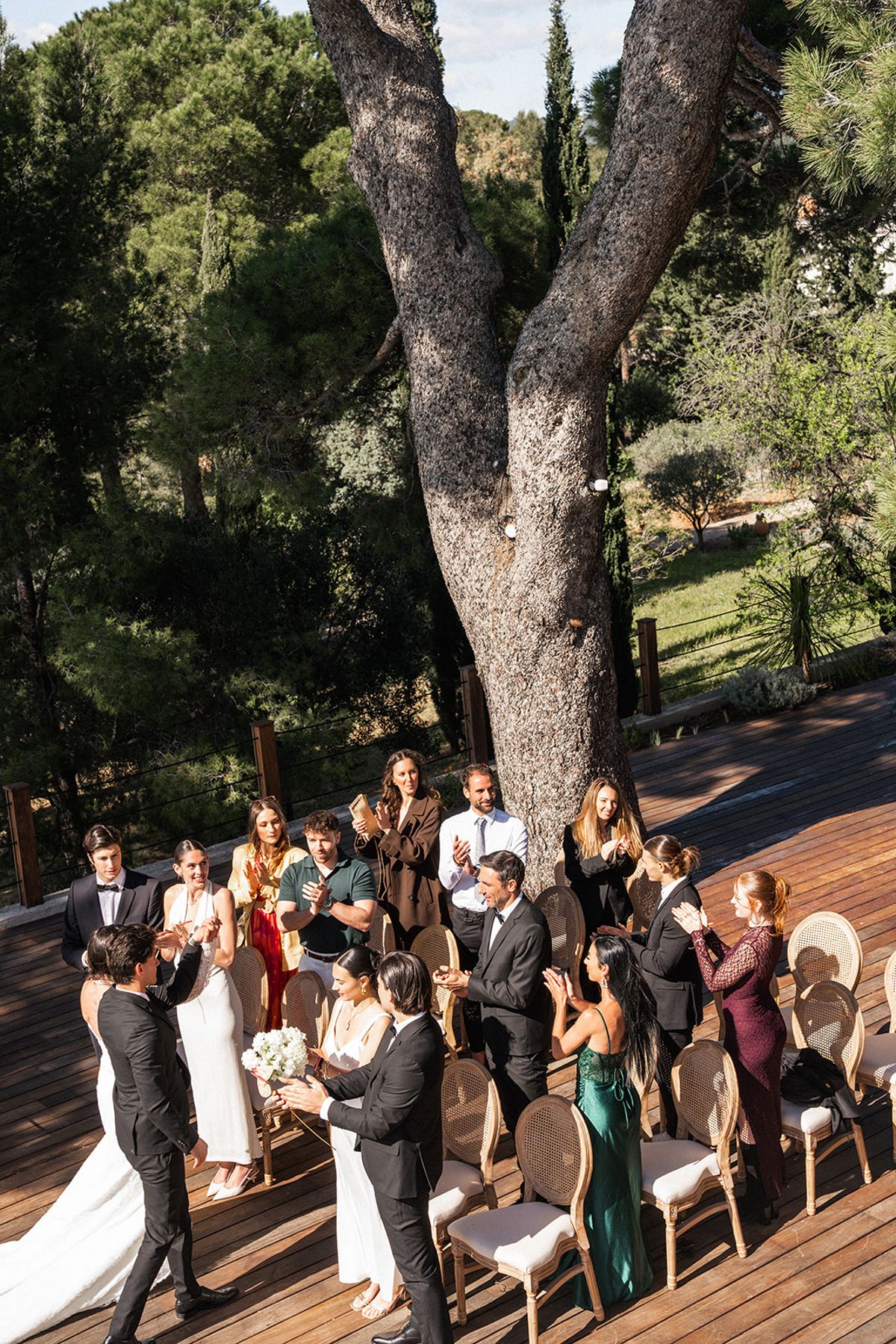 The couple exchange vows at the front of the ceremony deck, the Mediterranean spread out behind them.