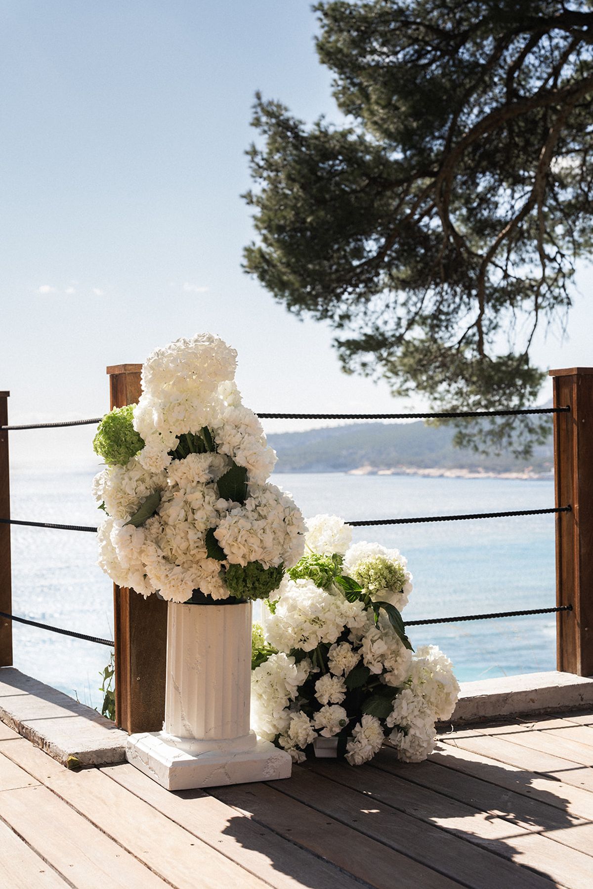 Guests applaud from their seats under the pine tree as the couple make their way back down the aisle.