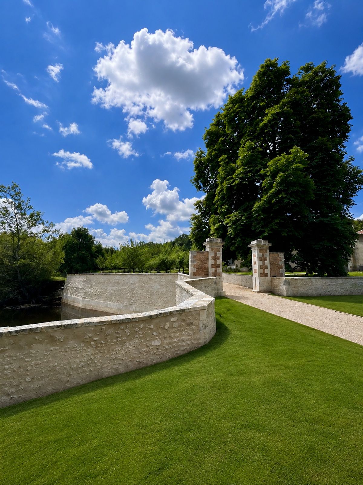 The curved stone wall and gate piers at the entrance to the grounds