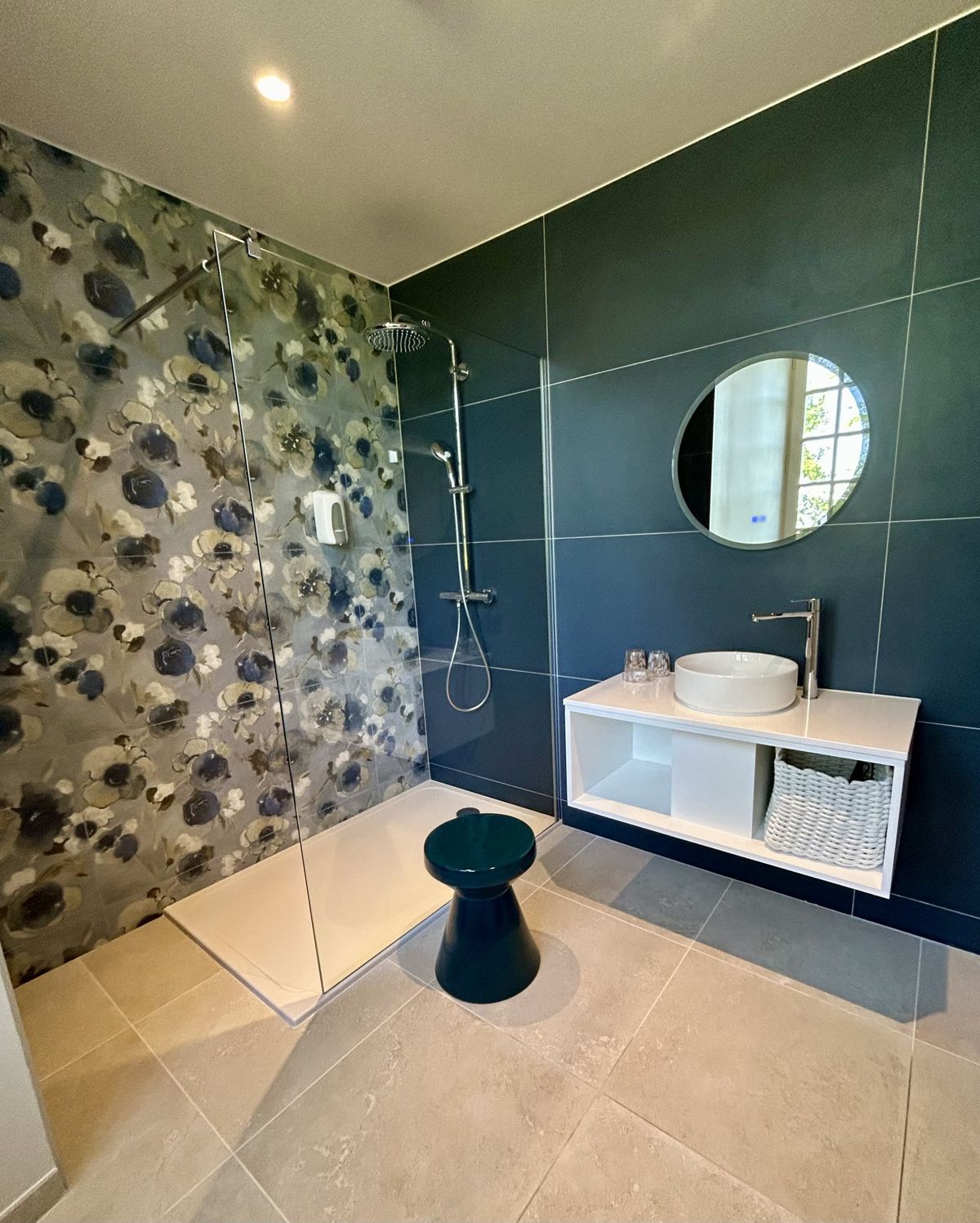 En-suite shower room with a walk-in shower, floral tiling and a round mirror