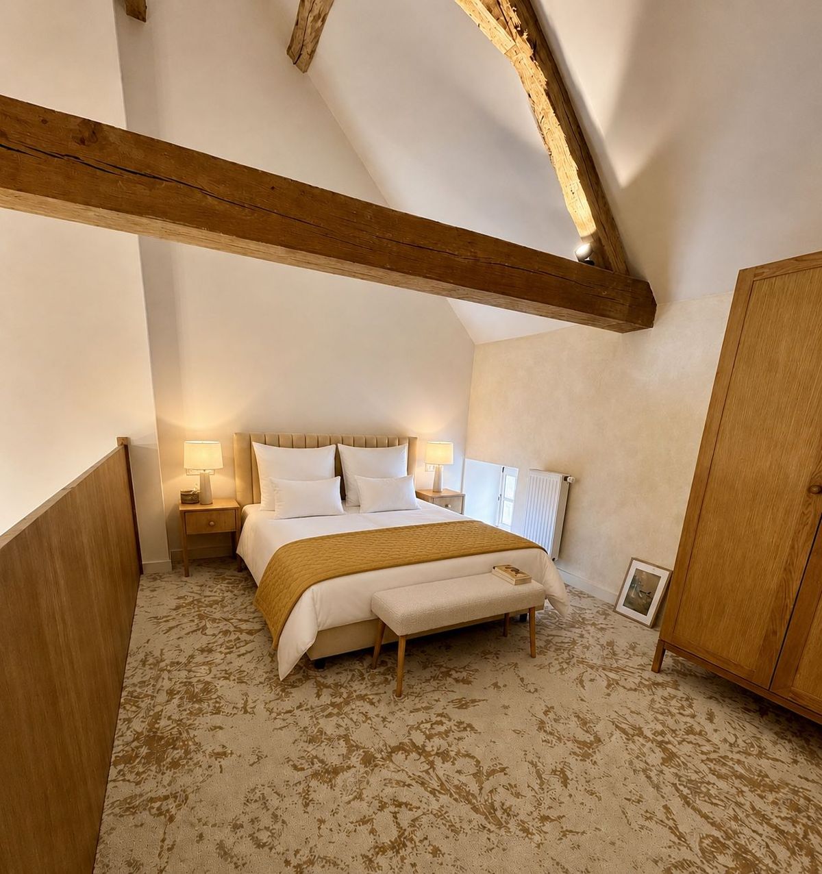 Guest bedroom under exposed beams, with a mustard throw and a bench at the foot of the bed