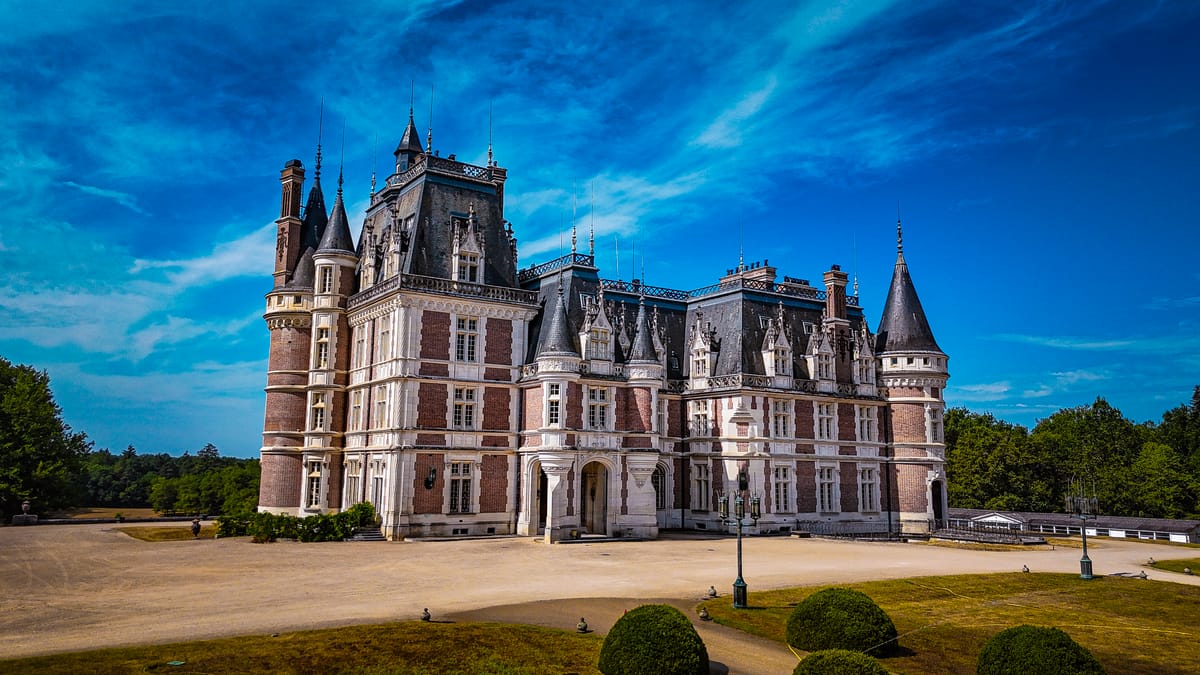 Château Changeux's facade and turrets against a blue sky
