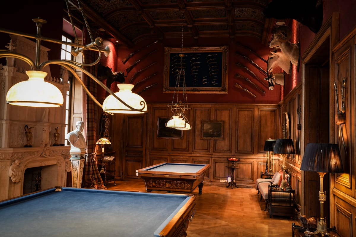 The games room at Château Changeux, with a billiard table and wood panelling