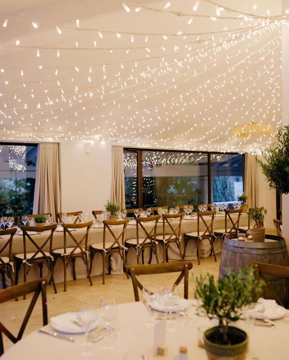The reception room at Domaine ODDO Vallon des Glauges set with long tables under a canopy of fairy lights