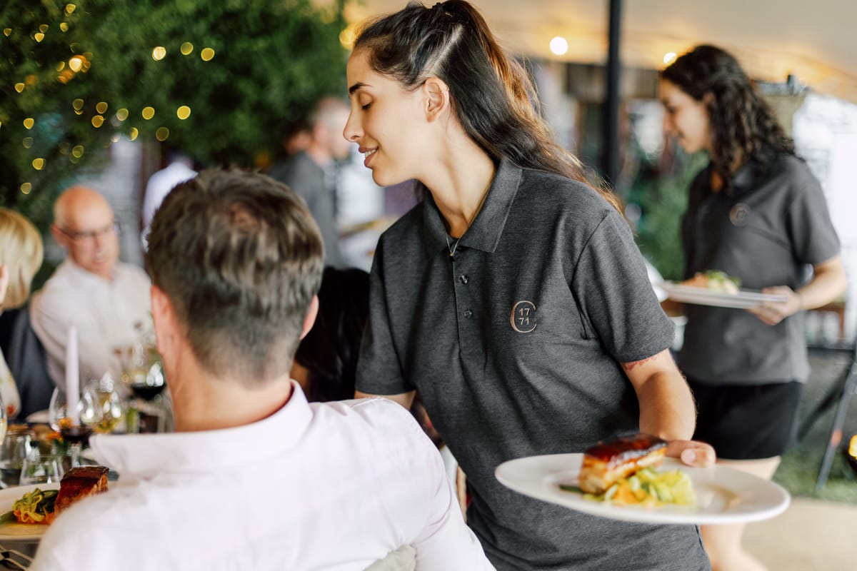 Hotel staff serving plated dinner to wedding guests