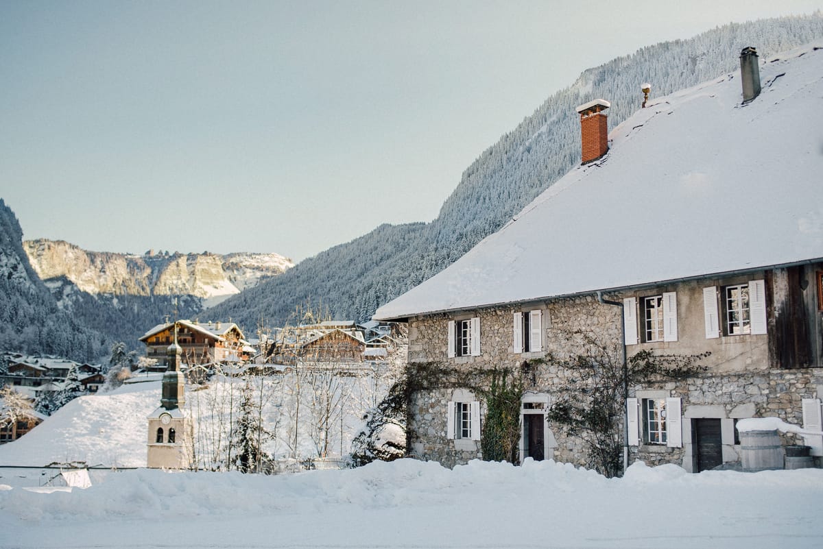 Hotel Coutettaz under snow on a clear winter day, with mountains behind
