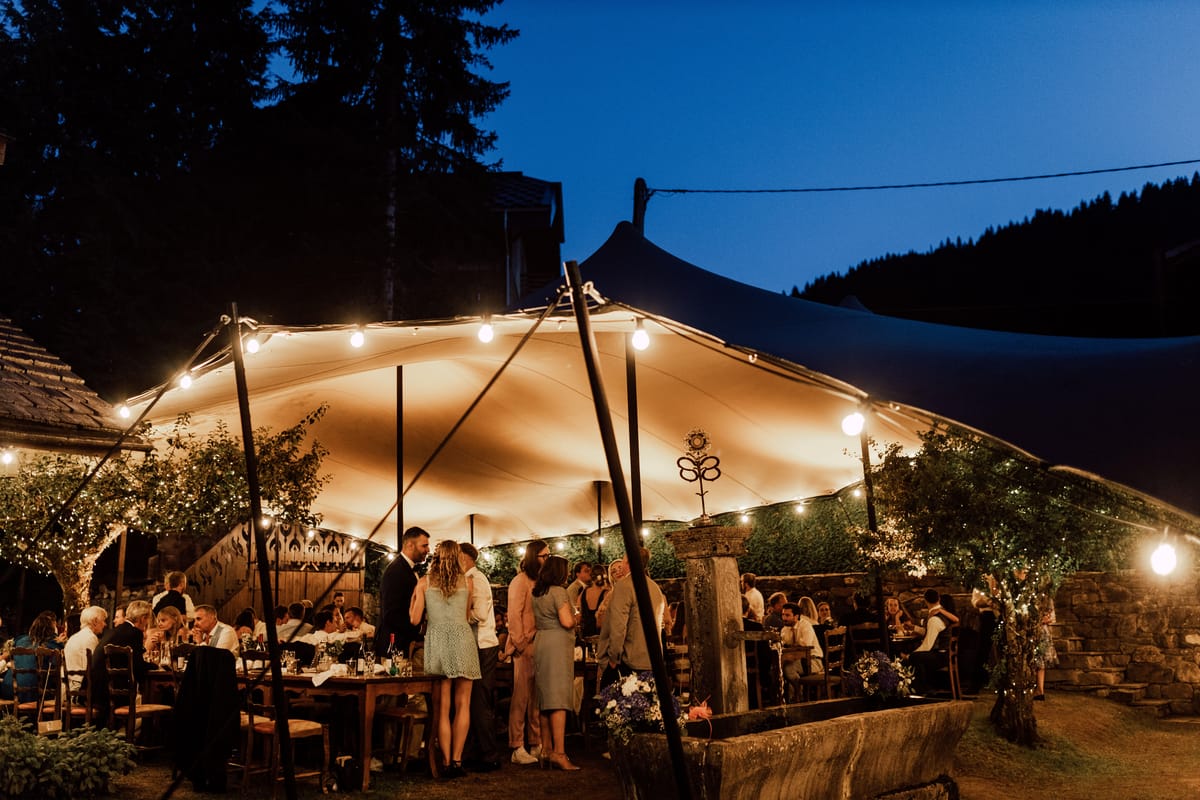Stretch tent lit with festoon lights for an evening dinner
