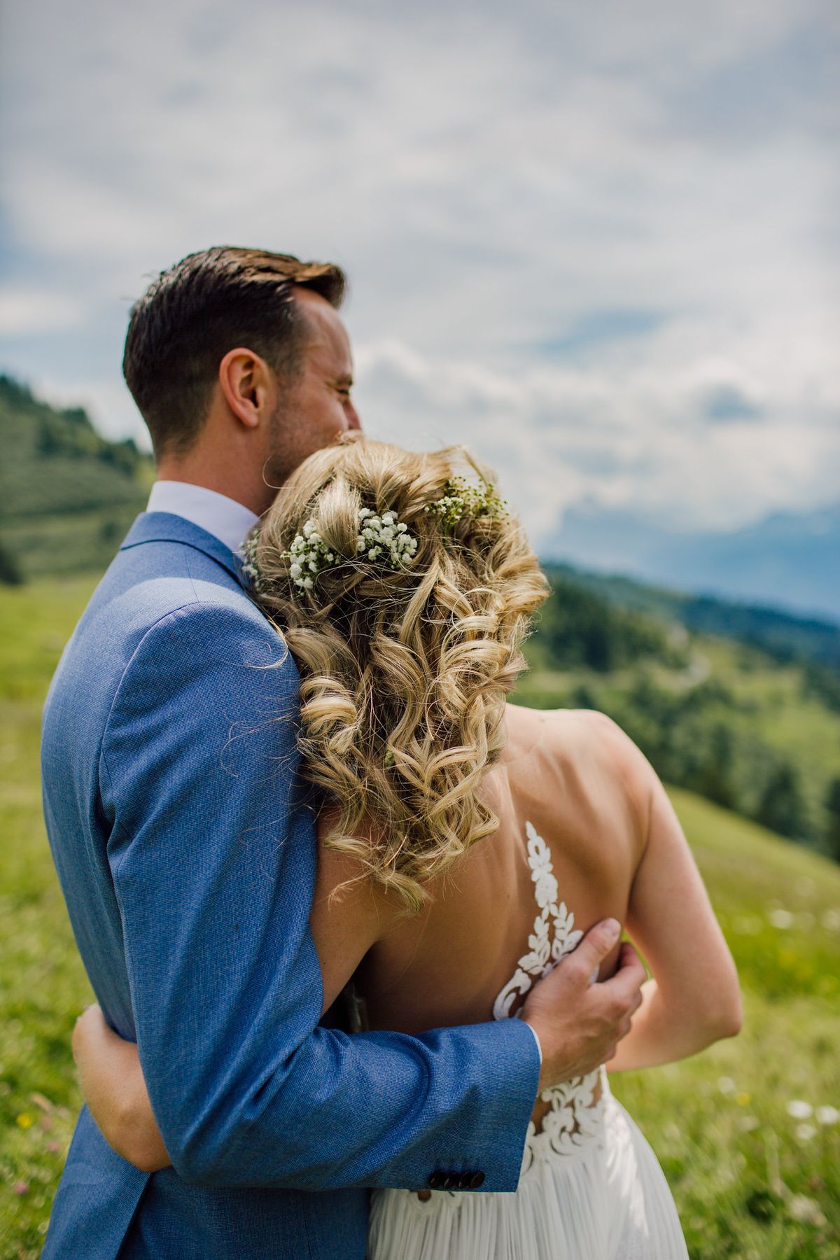 Bride and groom embracing on a mountain meadow