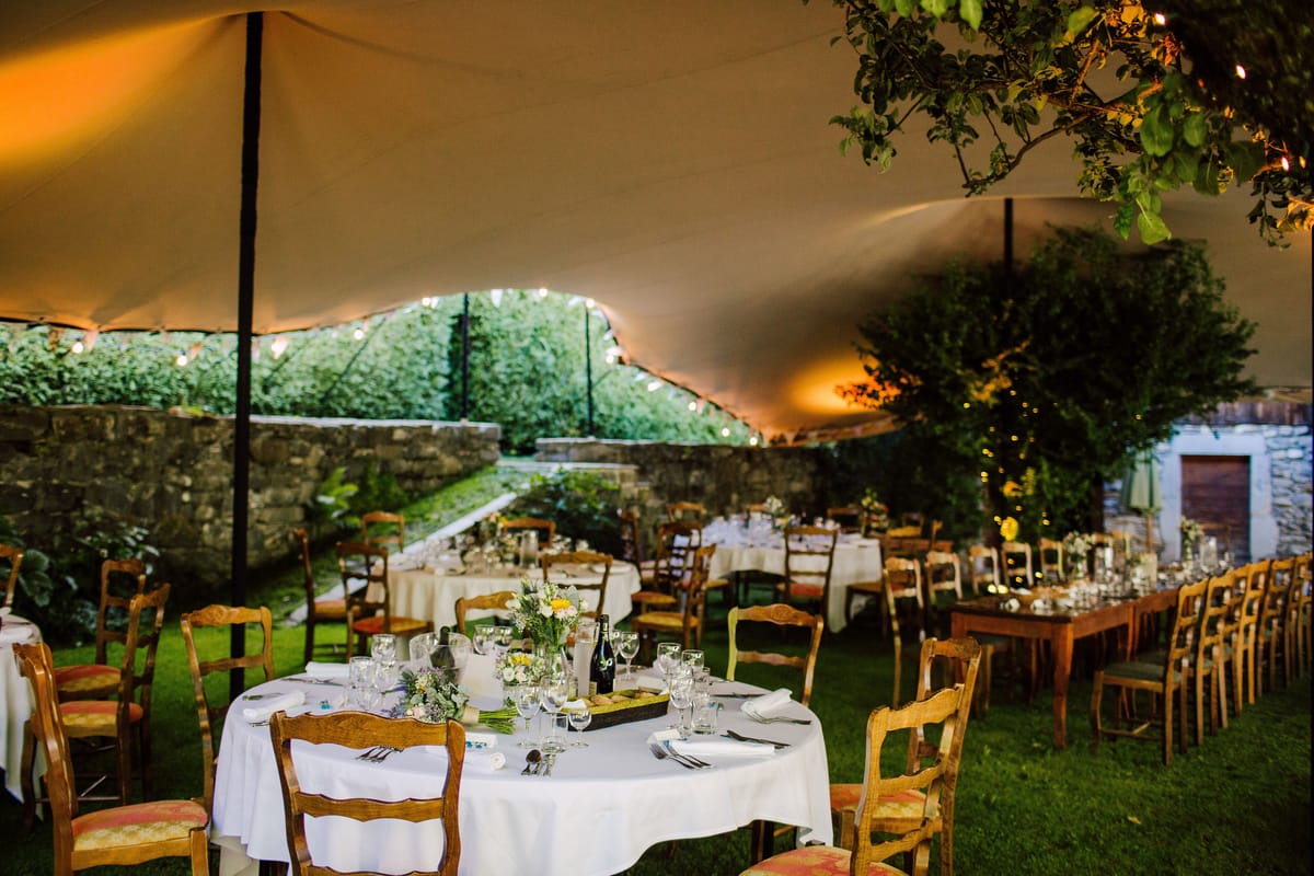 Round tables set for dinner under the stretch tent in the garden