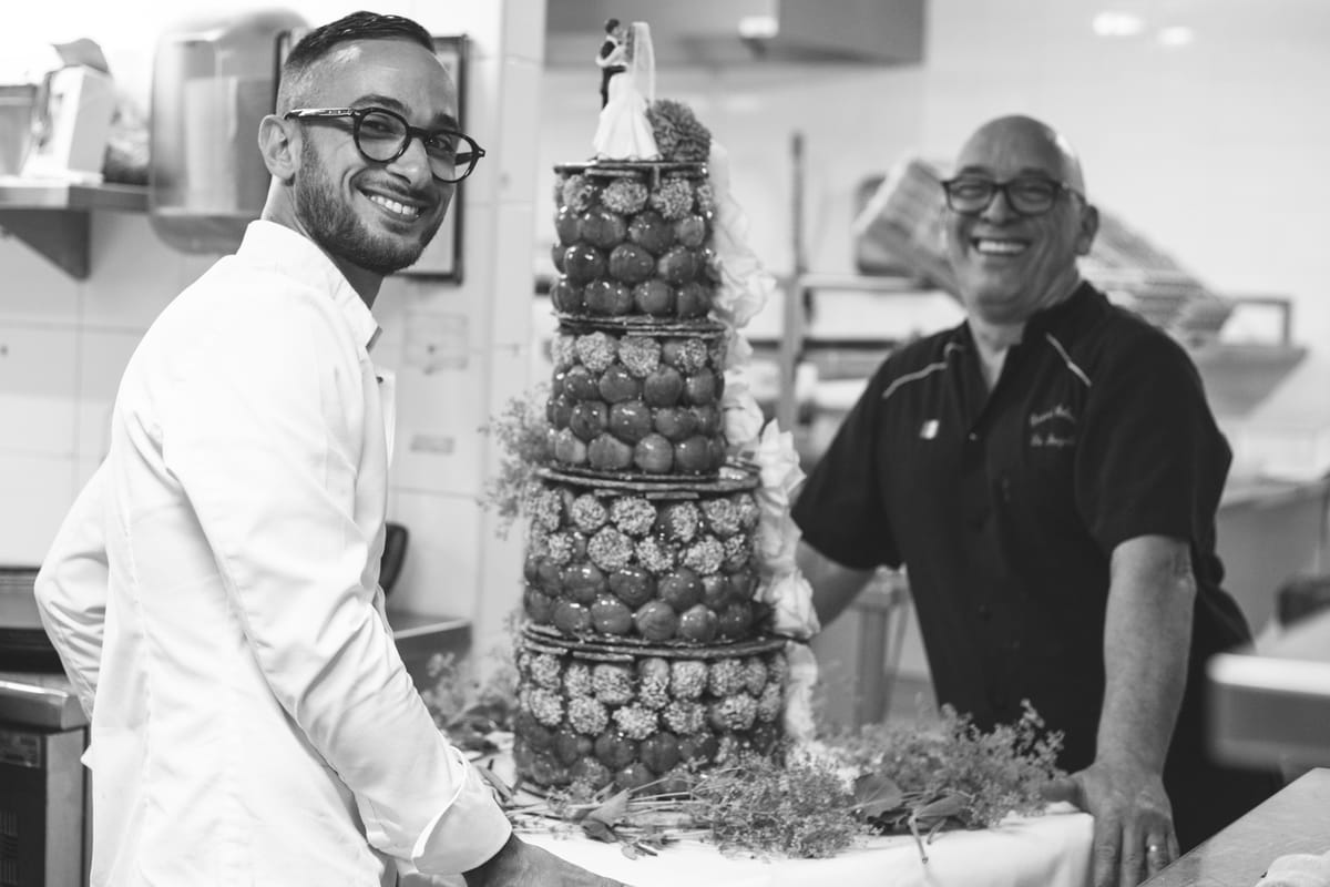 Black and white photo of 2 chefs with a croquembouche in the hotel kitchen