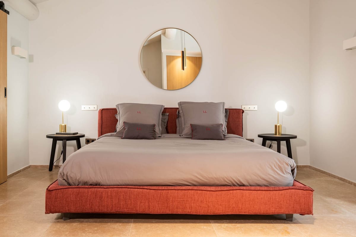 Domaine de Blacailloux bastide suite with terracotta bed frame, grey bedding and brass lamps