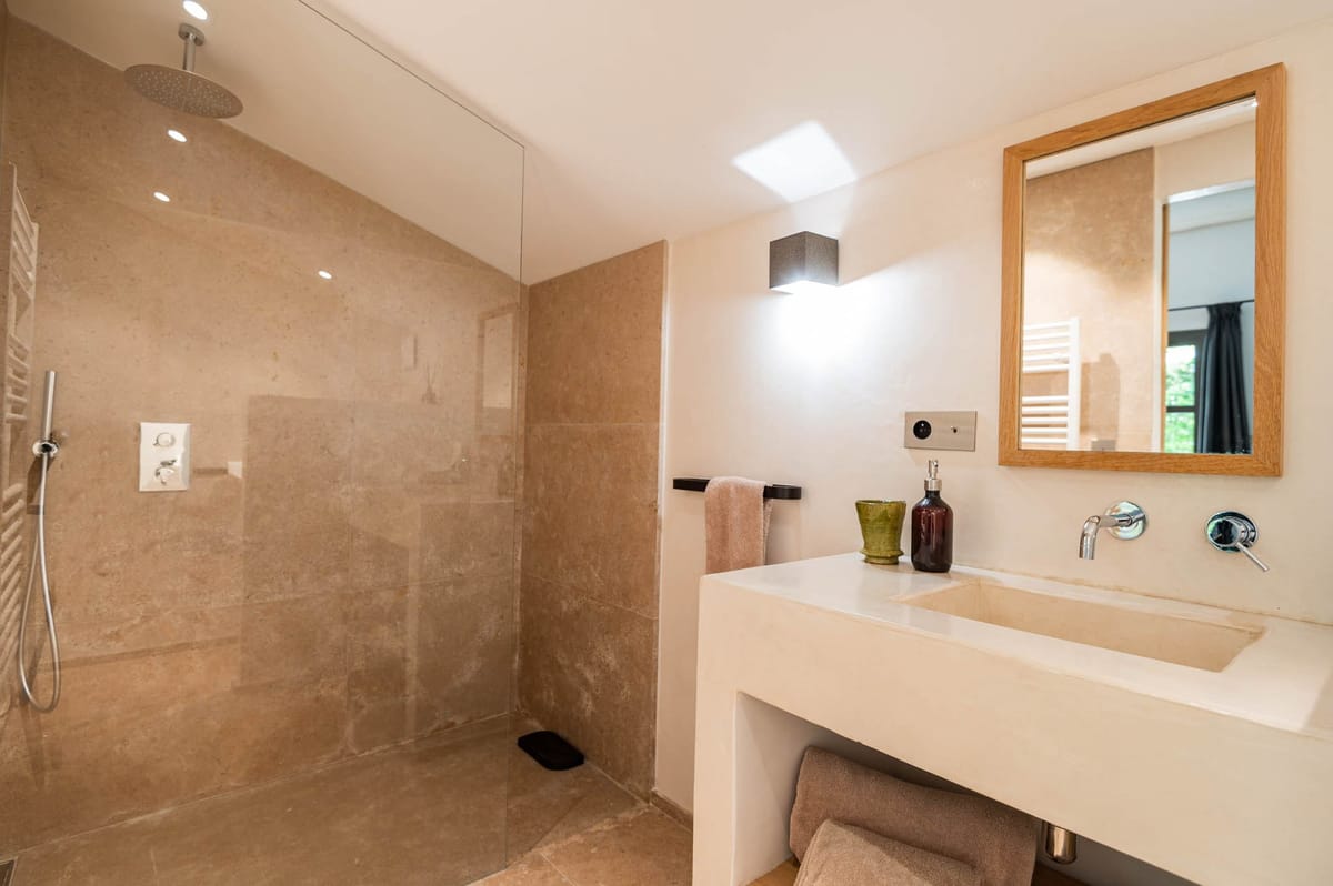 Domaine de Blacailloux bastide bathroom with stone rainfall shower and modern vanity