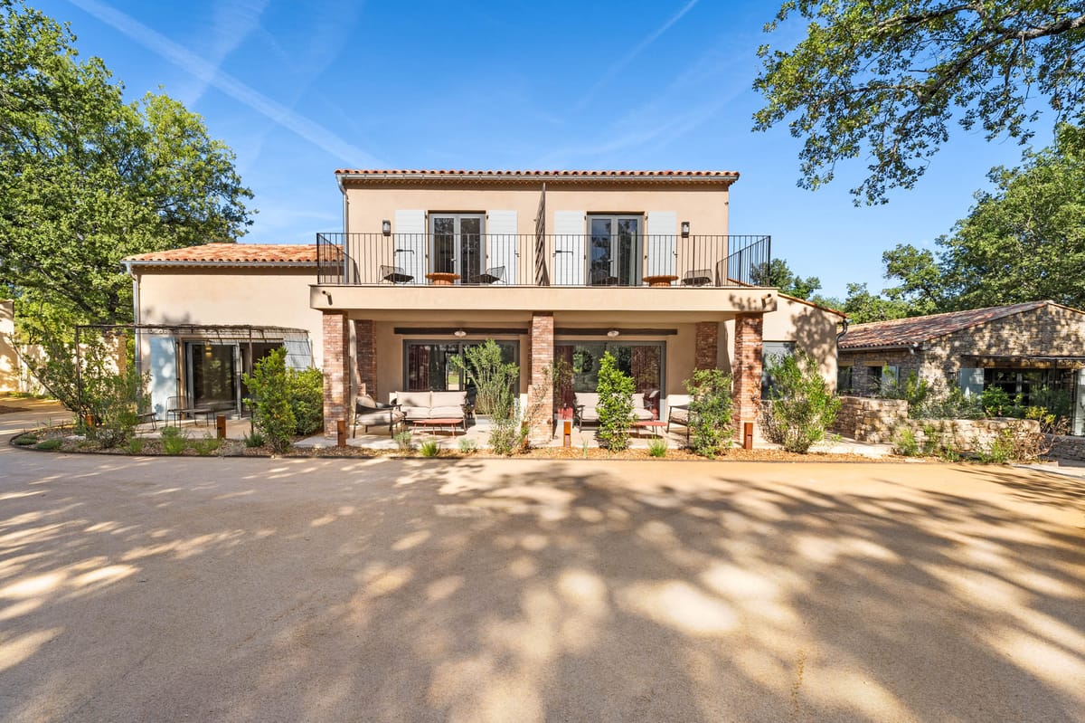 Front facade of Domaine de Blacailloux bastide with iron balcony and arcaded loggia