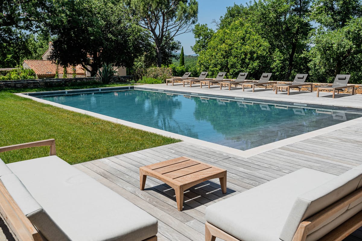Outdoor pool with teak loungers and daybeds at Domaine de Blacailloux